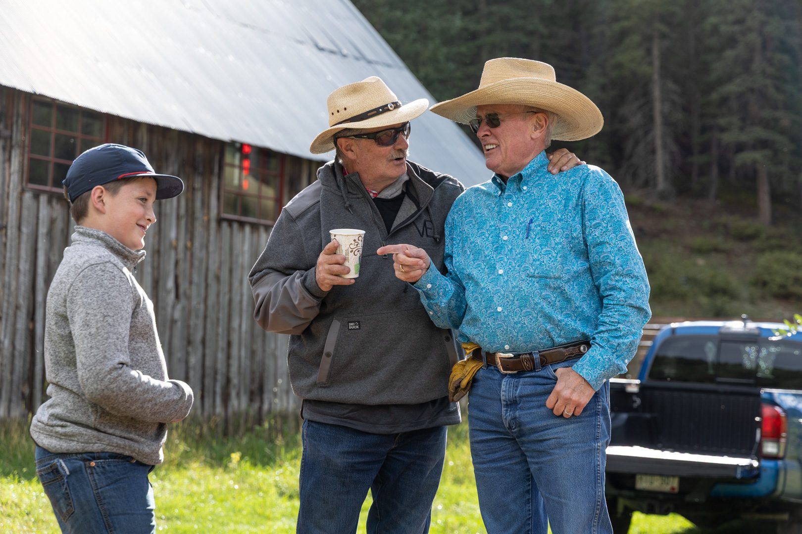 Three generations talking outside the barn