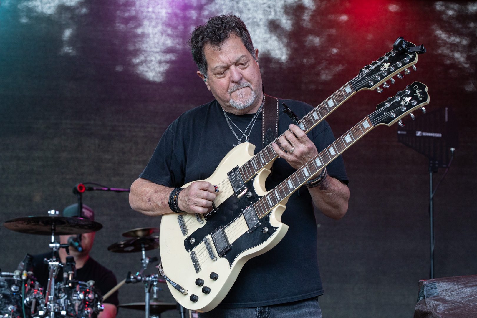 A guitarist on a double-neck guitar on the meadow stage
