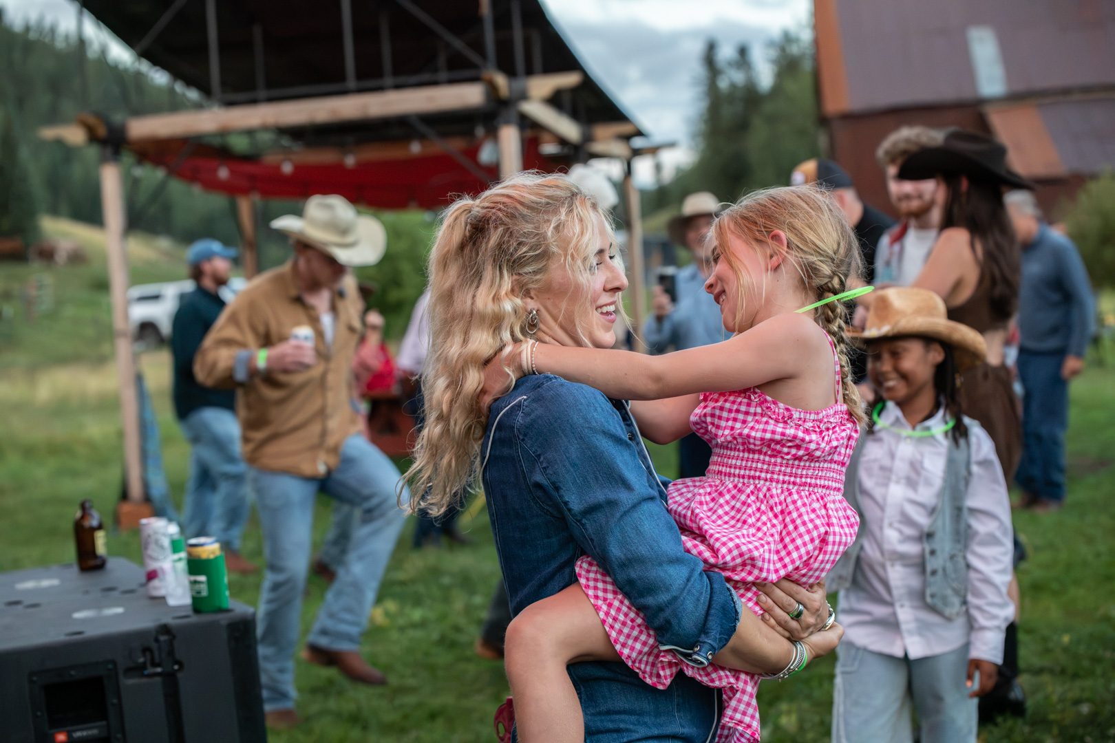 A mother swinging her daughter on the dance lawn, three generations around them