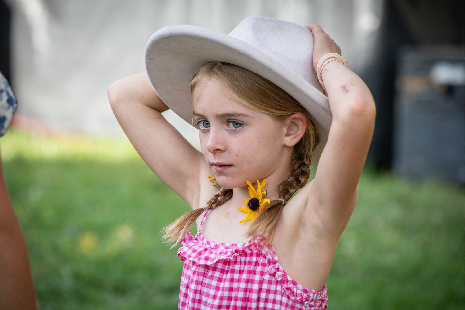 A young guest with a sunflower tucked in her braid at the barn dance