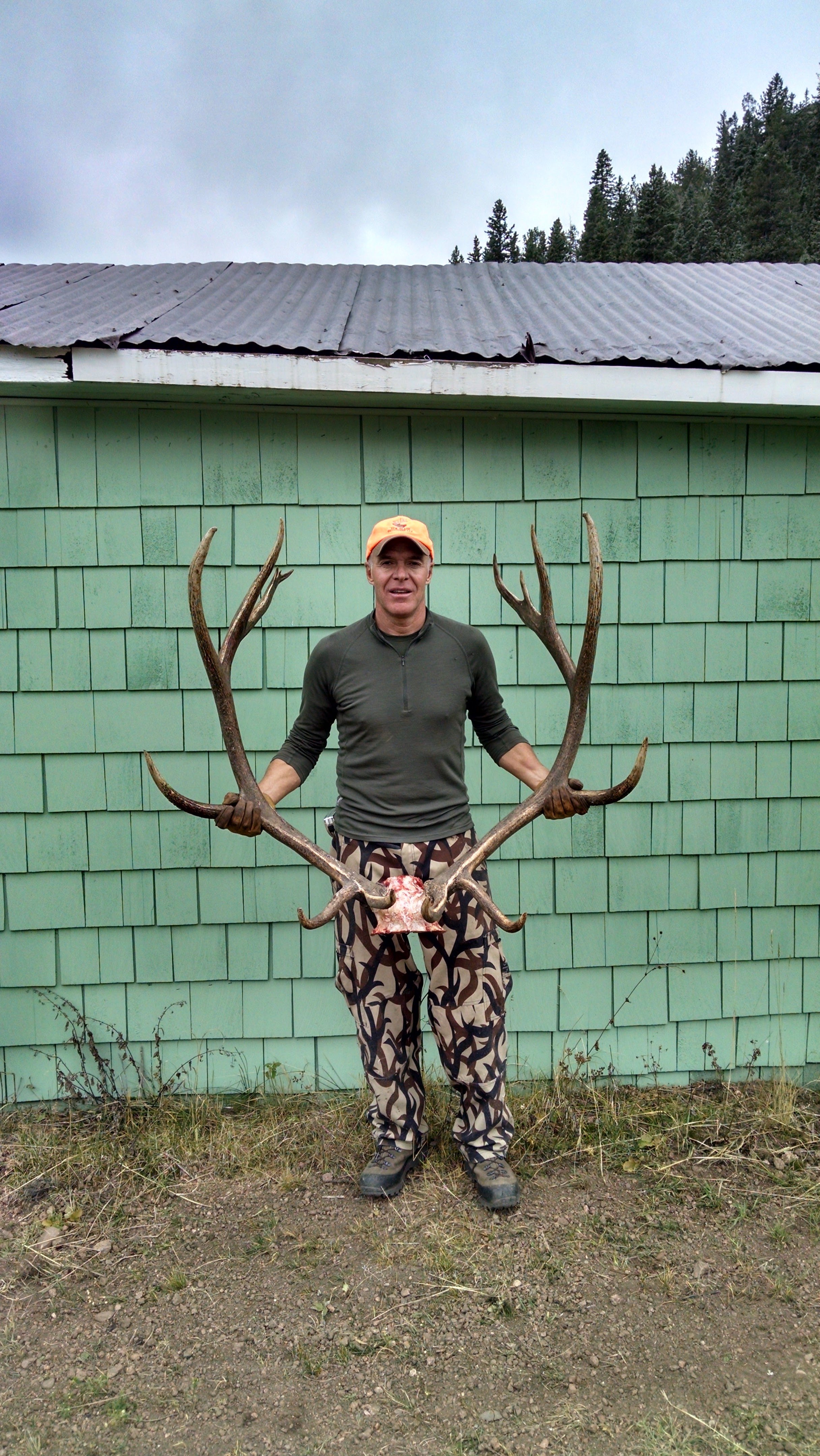 A hunter holding up a heavy set of bull elk antlers at the Elk Glade ranch