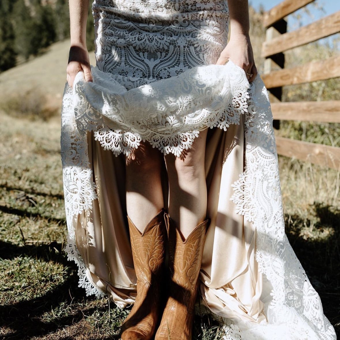 A bride's lace dress and cowboy boots at a ranch wedding