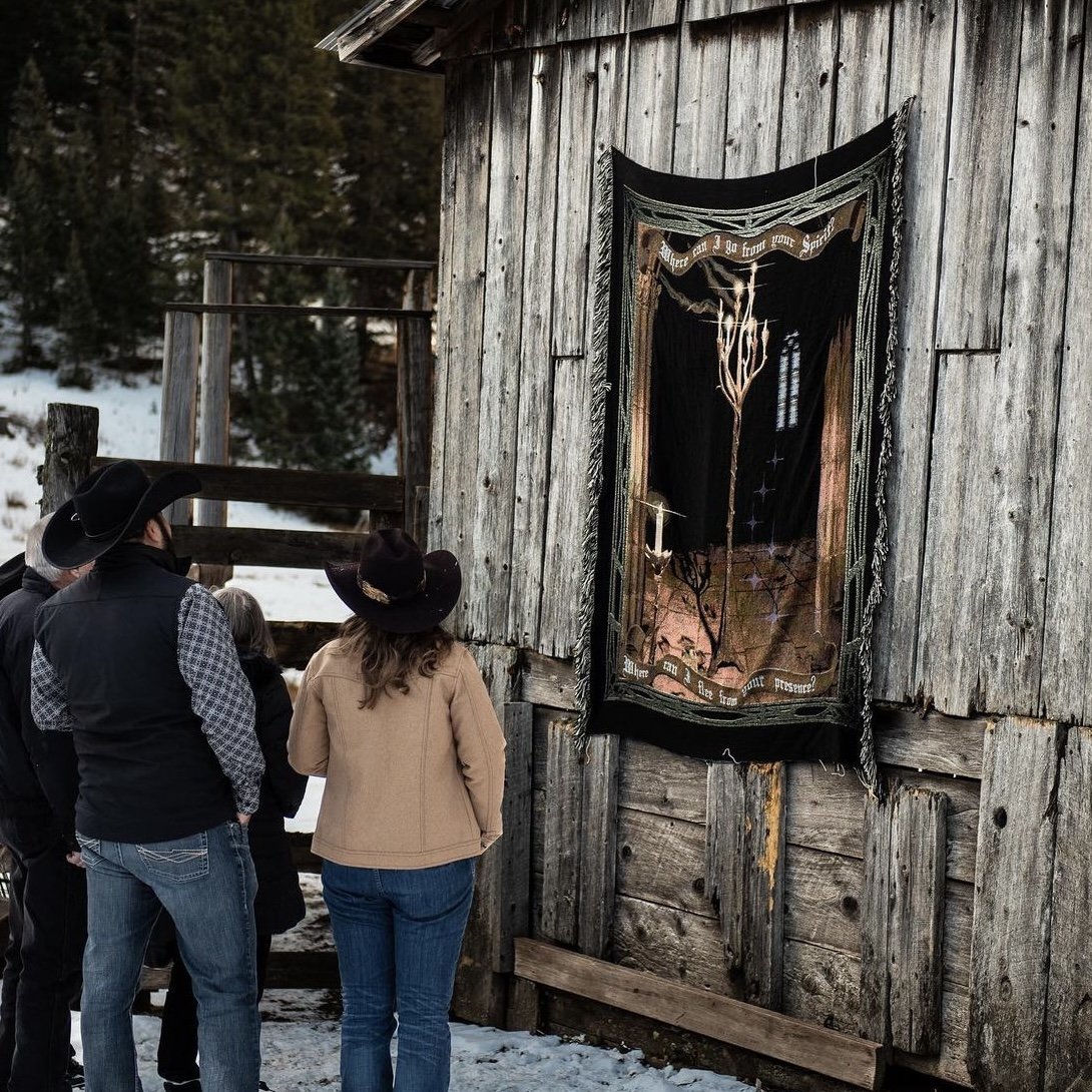 Guests at a weathered log cabin door on the ranch