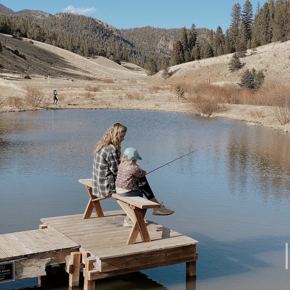 A woman and child fishing from a wooden dock on East Beaver Creek