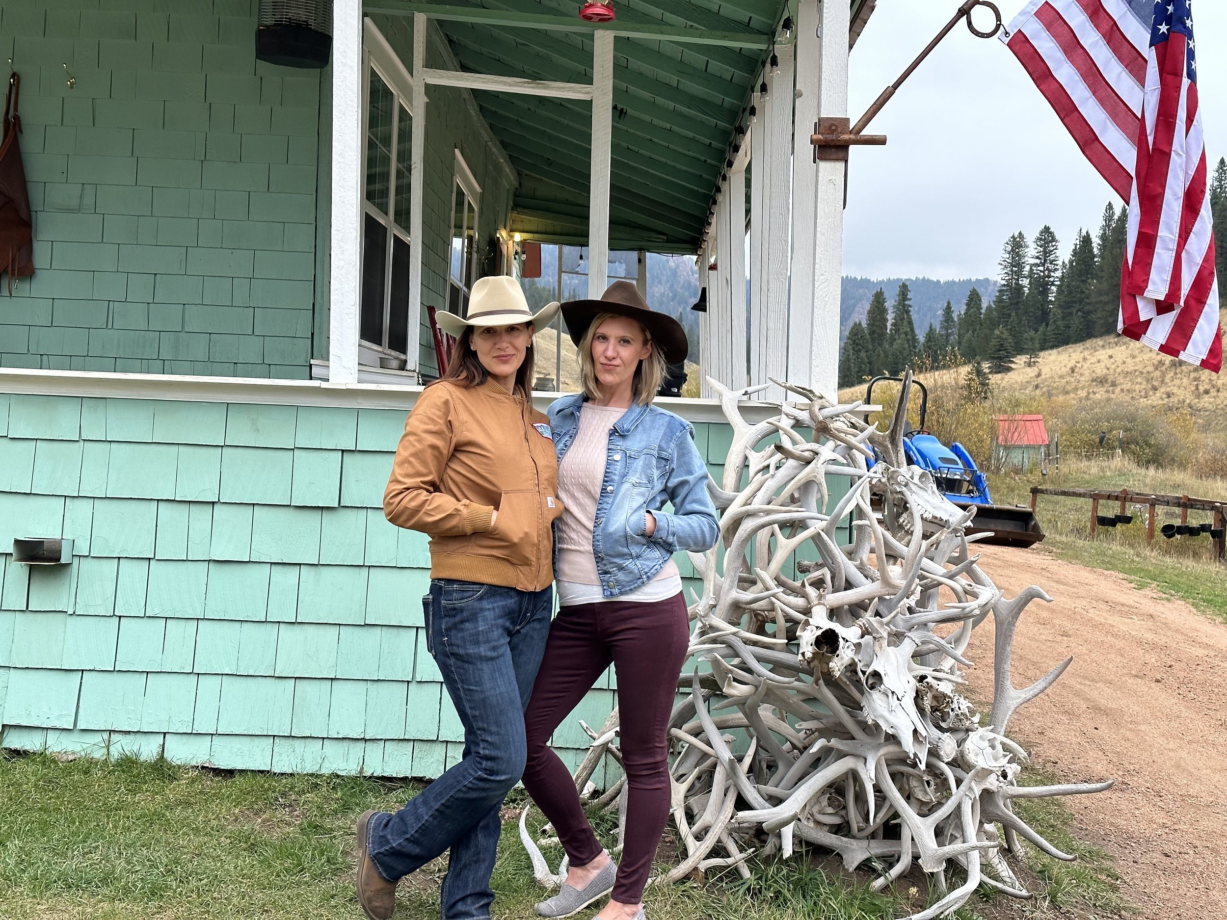 Two guests by the antler pile outside the ranch house during hunt week